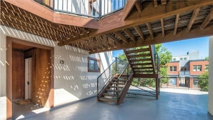 Un edificio moderno con una escalera de madera y un balcón.