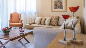 Una sala de estar con sofá, sillón, mesa de centro y objetos decorativos.
