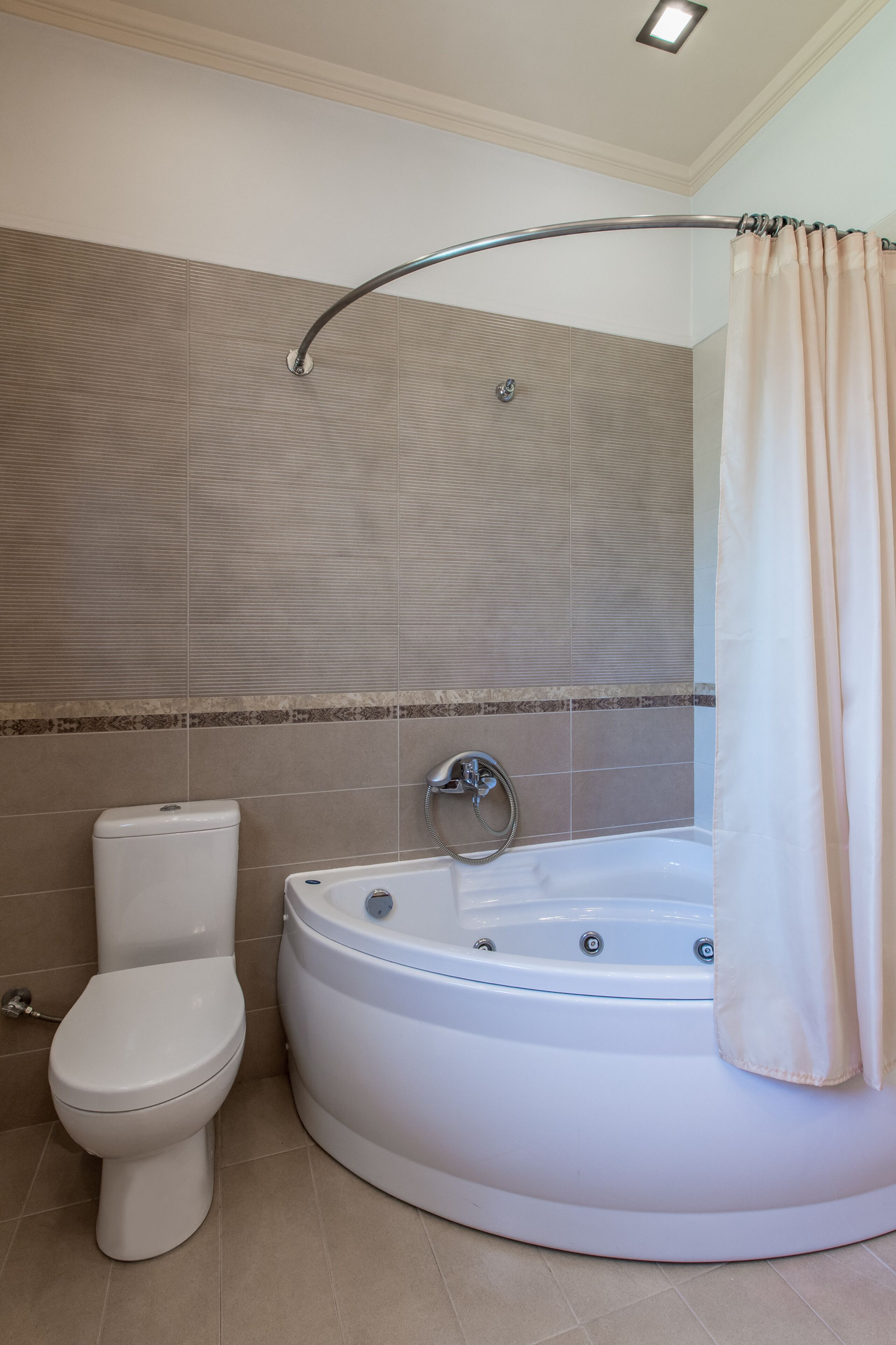 Un baño con inodoro, bañera y cortina de ducha.