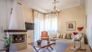 Una sala de estar con chimenea, un sofá, una mesa de centro y un televisor.