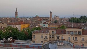 A cityscape with historical buildings, including a prominent tower and a dome. - Appartamento Daisy - Parma (Parma)