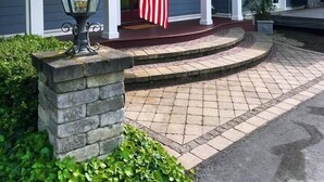 Een huis met een veranda, een stenen pilaar en een Amerikaanse vlag.