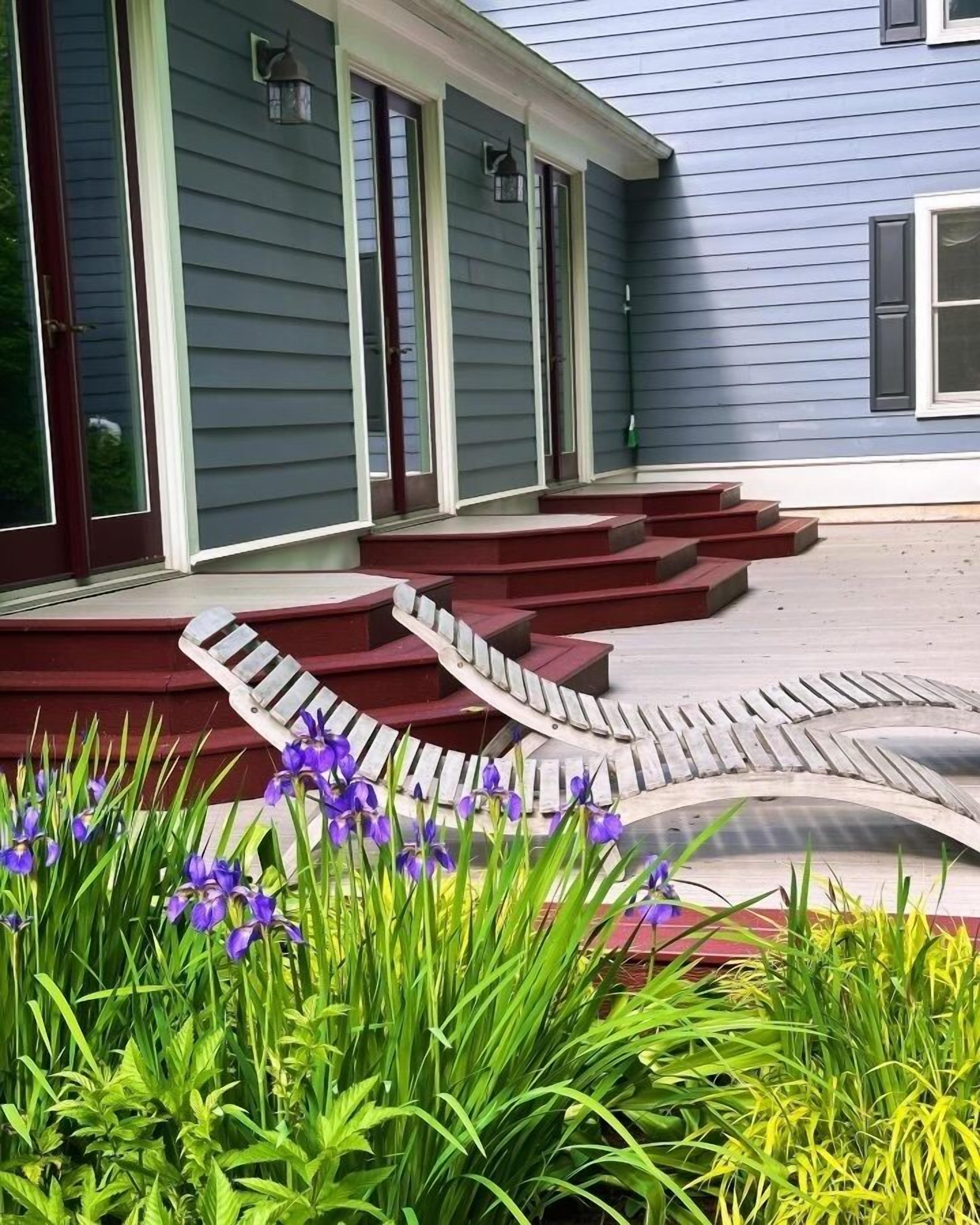 A house with a blue exterior, a red front door, and a set of red steps leading to a porch.