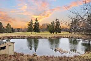 A pond with trees and a shed in a natural setting. - Lakeview Golf Retreat 1BDR Condo 5057 (Williamsburg)