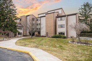 A multi-story residential building with a brick facade and large windows. - Lakeview Golf Retreat 1BDR Condo 5057 (Williamsburg)