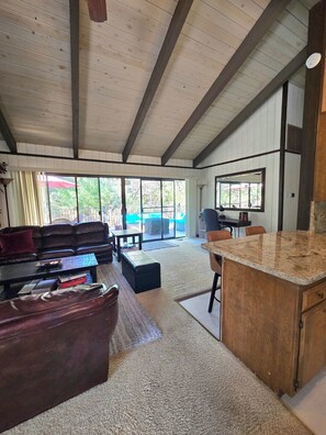 A spacious living area with a leather sofa, a coffee table, and a kitchen island with a granite countertop.