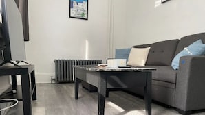 A modern living room with a grey sofa, a coffee table, and a radiator.