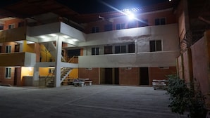 Un edificio de varios pisos con un patio central, escaleras y una fuente de luz brillante.