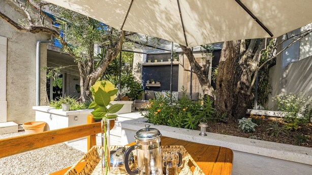 An outdoor seating area with a table set for two, a coffee pot, and a tray. - Magical Garden with Shared Jacuzzi - Blanka C2 (Banjol)