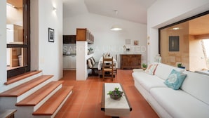 Un salon moderne avec un canapé, une table basse et un escalier menant à l’étage supérieur.