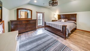 Un dormitorio con una cama grande, cómoda y espejo.