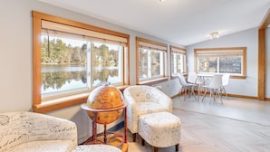 A room with large windows, a globe on a stand, and a table with chairs. - Lakefront Salem Retreat - Fish, Swim, Kayak & More (Salem)