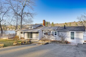 Una casa a un piano con garage, camino e un piccolo giardino antistante con vialetto che conduce all'ingresso.
