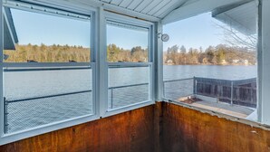 A cabin with large windows overlooking a lake, a wooden deck, and a metal railing. - Lakefront Salem Retreat - Fish, Swim, Kayak & More (Salem)