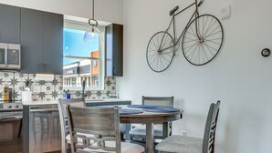 A modern kitchen with dark cabinets, a built-in oven, and a dining area with a round table and chairs. - Pet-Friendly New Braunfels Condo w/ Shared Pool! (New Braunfels)