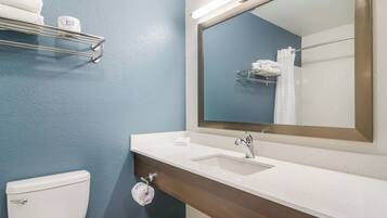 A bathroom with a white sink, a mirror, a towel rack, and a toilet.