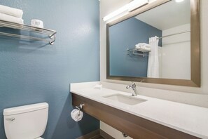 Un baño con un lavabo blanco, un espejo, toallero y un inodoro.