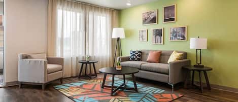 A modern living room with a sofa, armchair, coffee table, and two side tables.