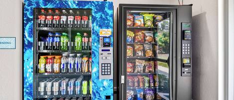 Two beverage vending machines with a variety of drinks and snacks.