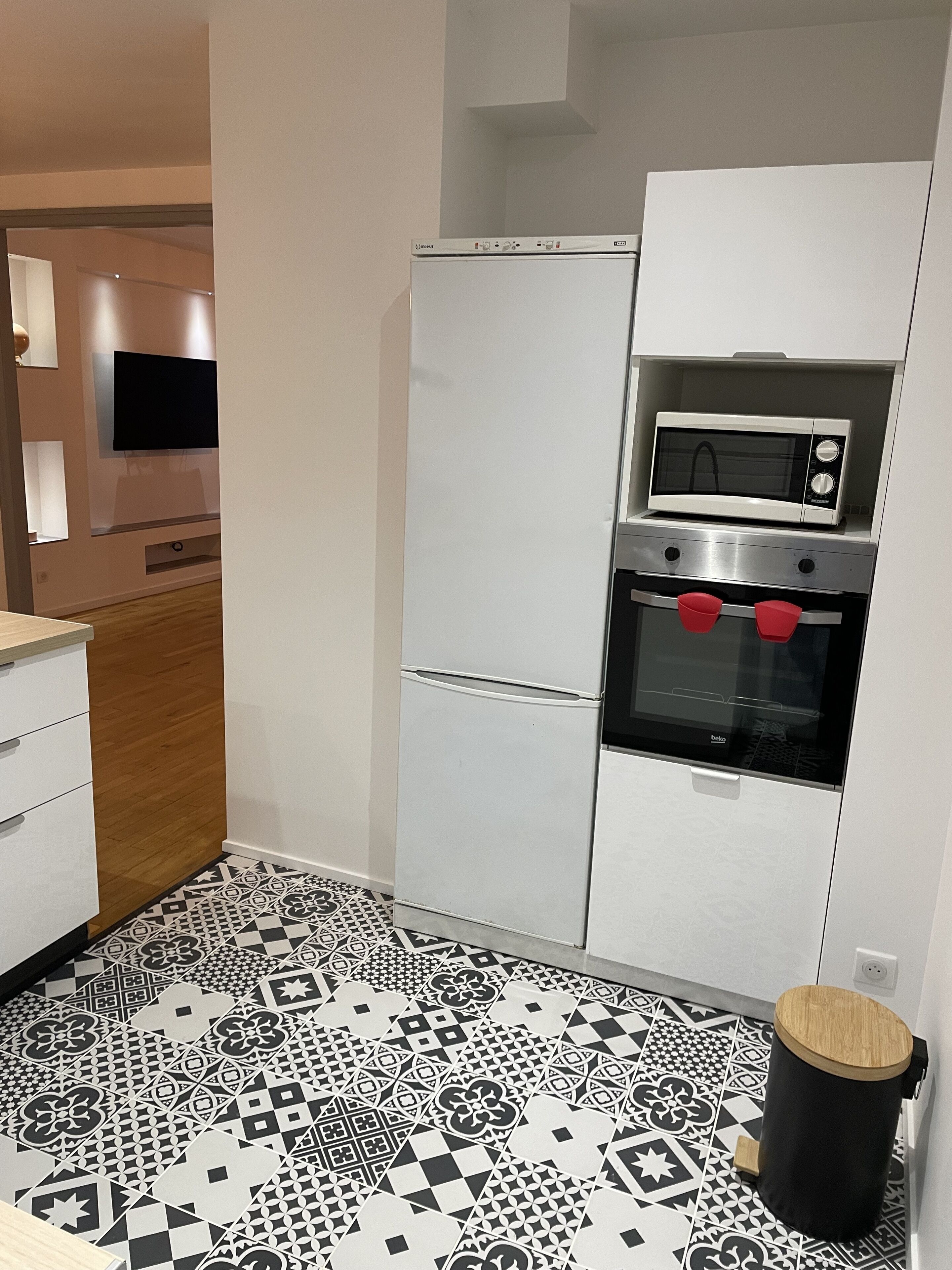 Een moderne keuken met een magnetron, oven en koelkast.