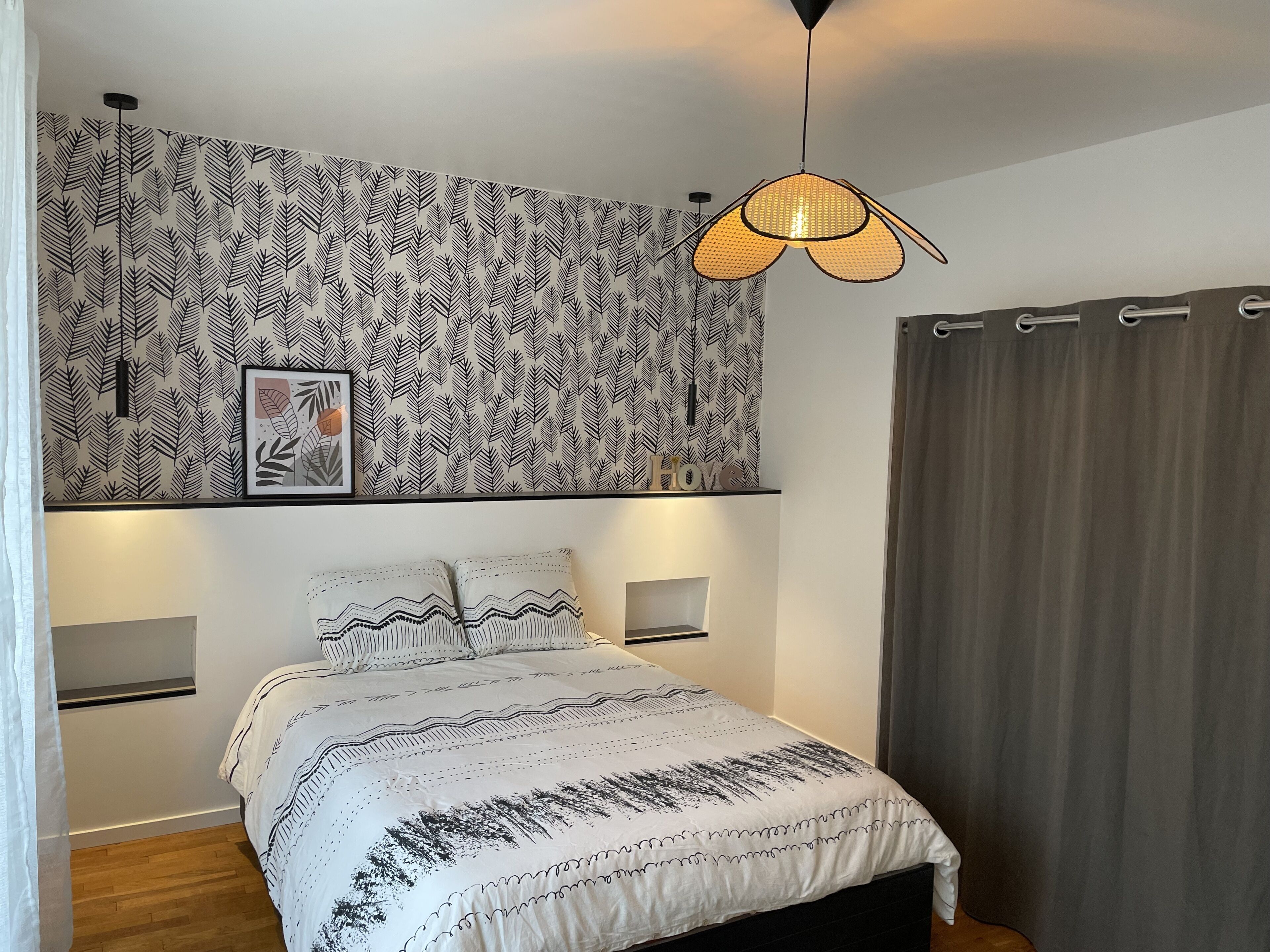 Una camera da letto con un letto, un arazzo a parete, un lampadario e una tenda.