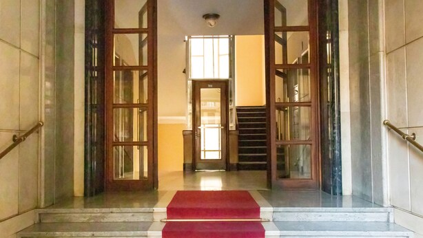 A grand entrance with a red carpet leading to a staircase. - Romatic Guest House  (Rome)