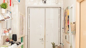 A compact kitchen with white cabinets, a countertop with various items, a dining table with food, and a white door. - Romatic Guest House  (Rome)