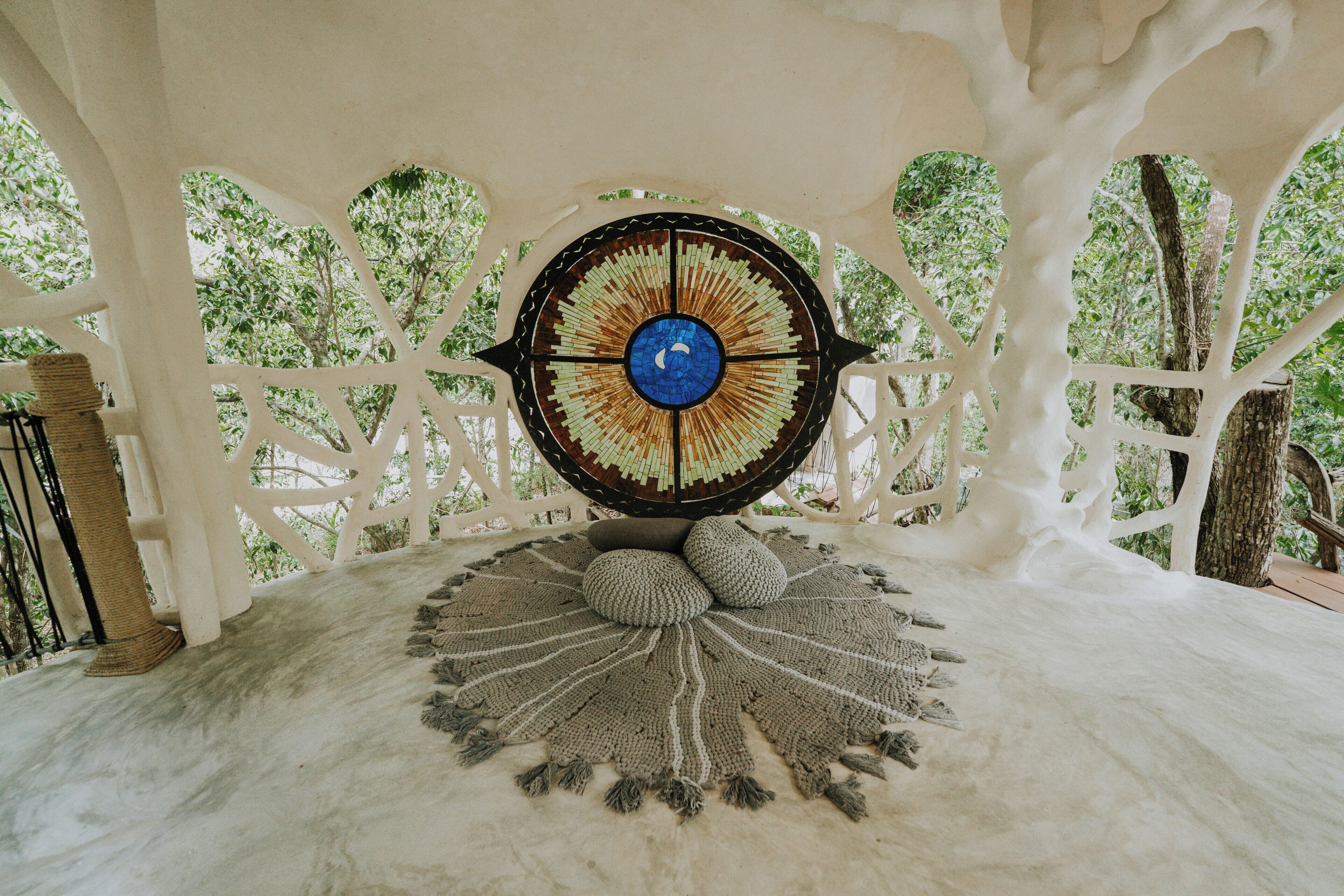 A circular mosaic artwork with a central blue circle and radiating patterns, surrounded by a white lattice structure.