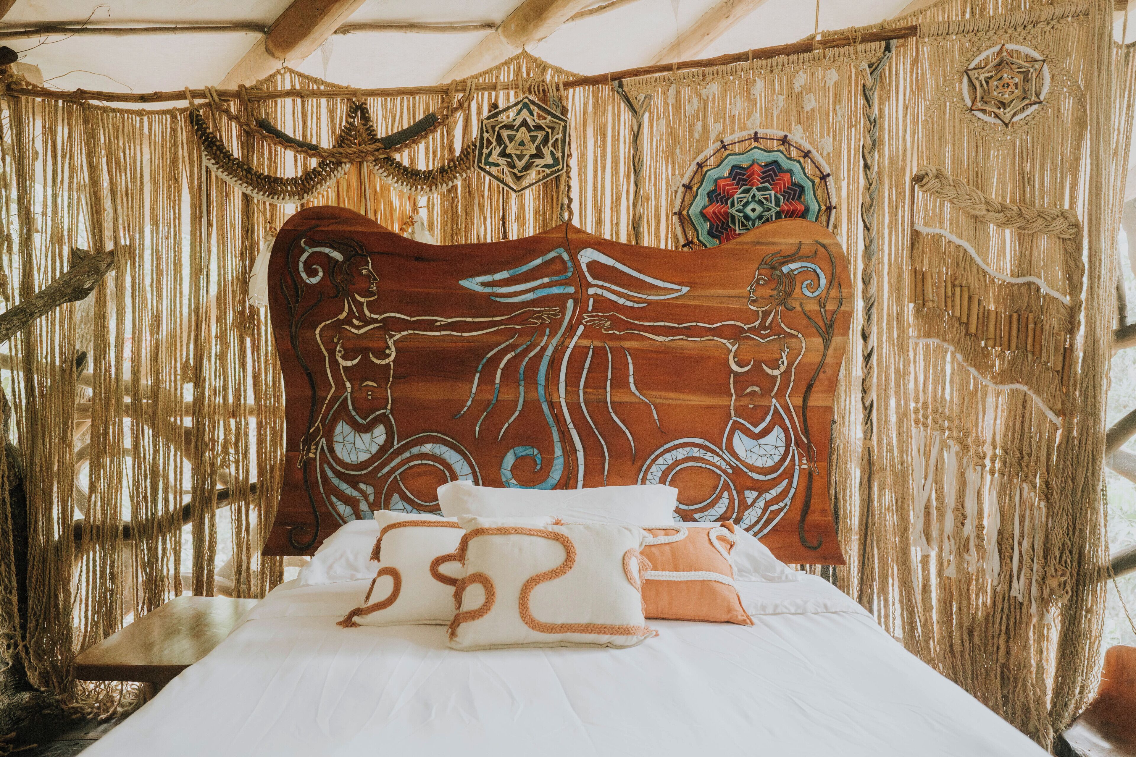 A bed with a wooden headboard, white bedding, and decorative pillows.