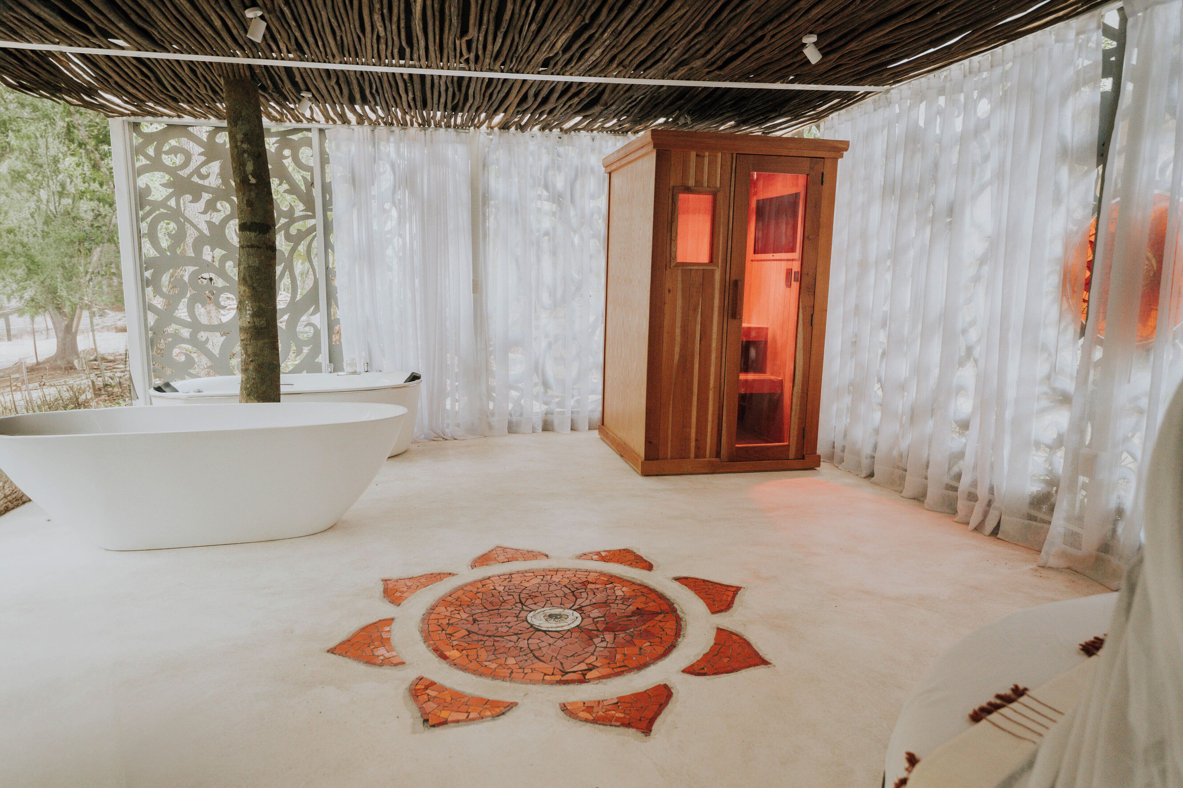 Un baño con bañera, un armario de madera y piso estampado.