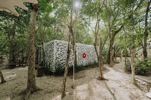 Un sendero bordeado de árboles y una valla blanca decorativa con diseños intrincados.