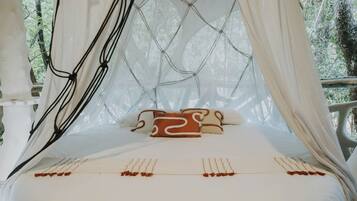 A bed with a canopy, pillows, and a string of decorative items.