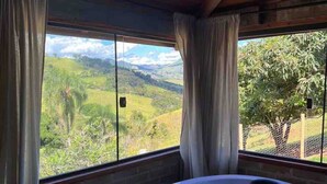 A hot tub with a view of a mountainous landscape through large windows. - Cabana I nas Montanhas de Gonçalves (Gonçalves)