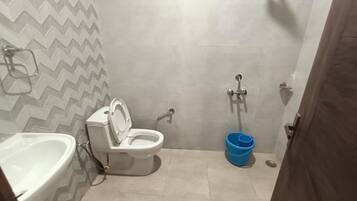 A small bathroom with a toilet, bidet, and sink.