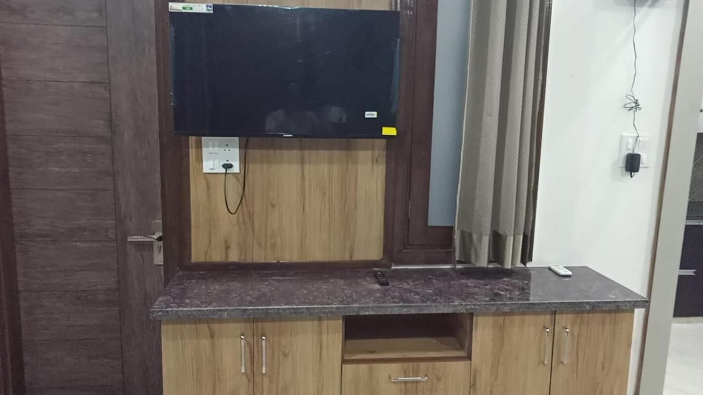 A wooden cabinet with a flat-screen TV mounted above it.