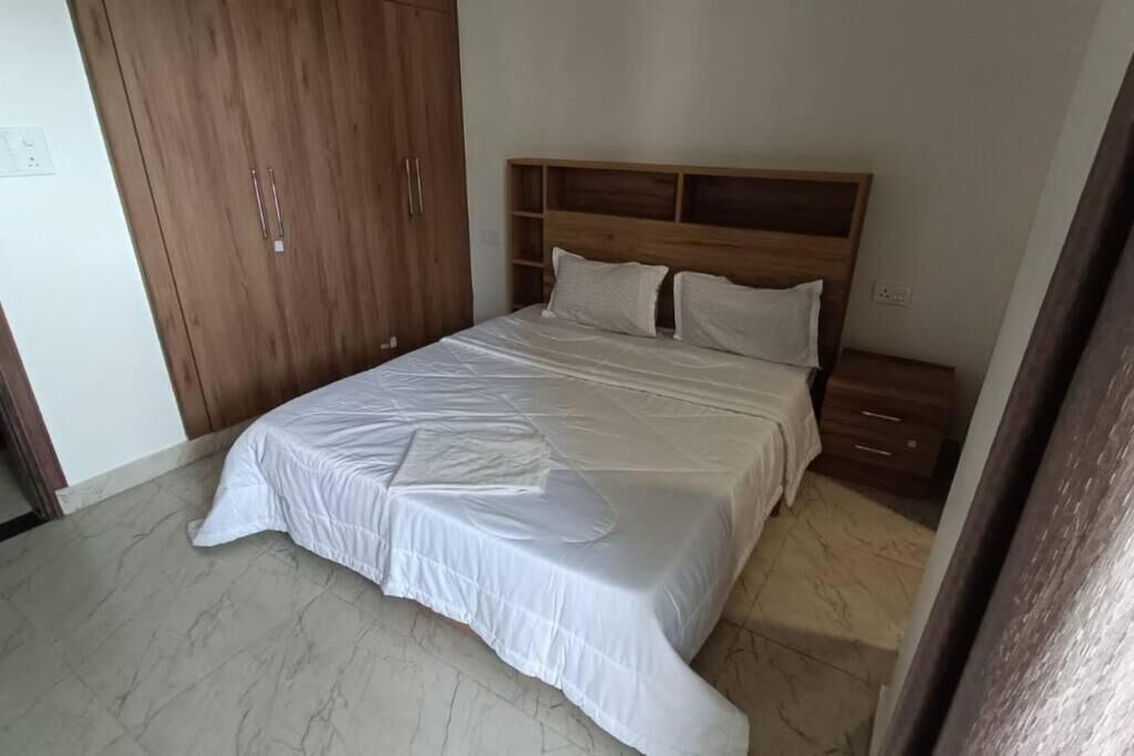 Ein Schlafzimmer mit Bett, Holzschrank und Nachttisch.