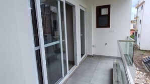 A narrow corridor with a glass door leading to a balcony. - 85 The Ganges 2 Bhk Apartment for Homestay (Rishikesh)