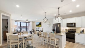 Een moderne keuken met witte kastjes, een centraal eiland en roestvrijstalen apparatuur.