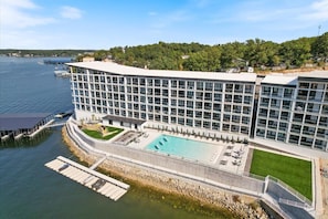 Un hotel moderno con una piscina grande, vistas al agua y un muelle.