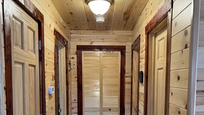A wooden hallway with double doors and a ceiling light fixture. - Riverfront Cabin: The Cozy Southern Brook Trout Lodge  (Luzene)