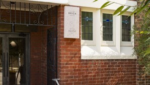 Un bâtiment en briques sur lequel on peut lire l’inscription : « The Brick Hotel ».