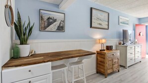 A kitchen with a wooden countertop, white bar stools, a wooden cabinet, and a white dresser. - Great Summer Rates 1B 1B South beach-Steps to pool-beach-restaurants-nightlife! (Tybee Island)