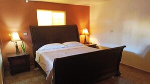 Ein Schlafzimmer mit einem Bett, zwei Nachttischen und einem Fenster.