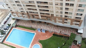 A high-rise building with a rooftop swimming pool and a small circular pool. - Oceanografico Apartments (Valencia)