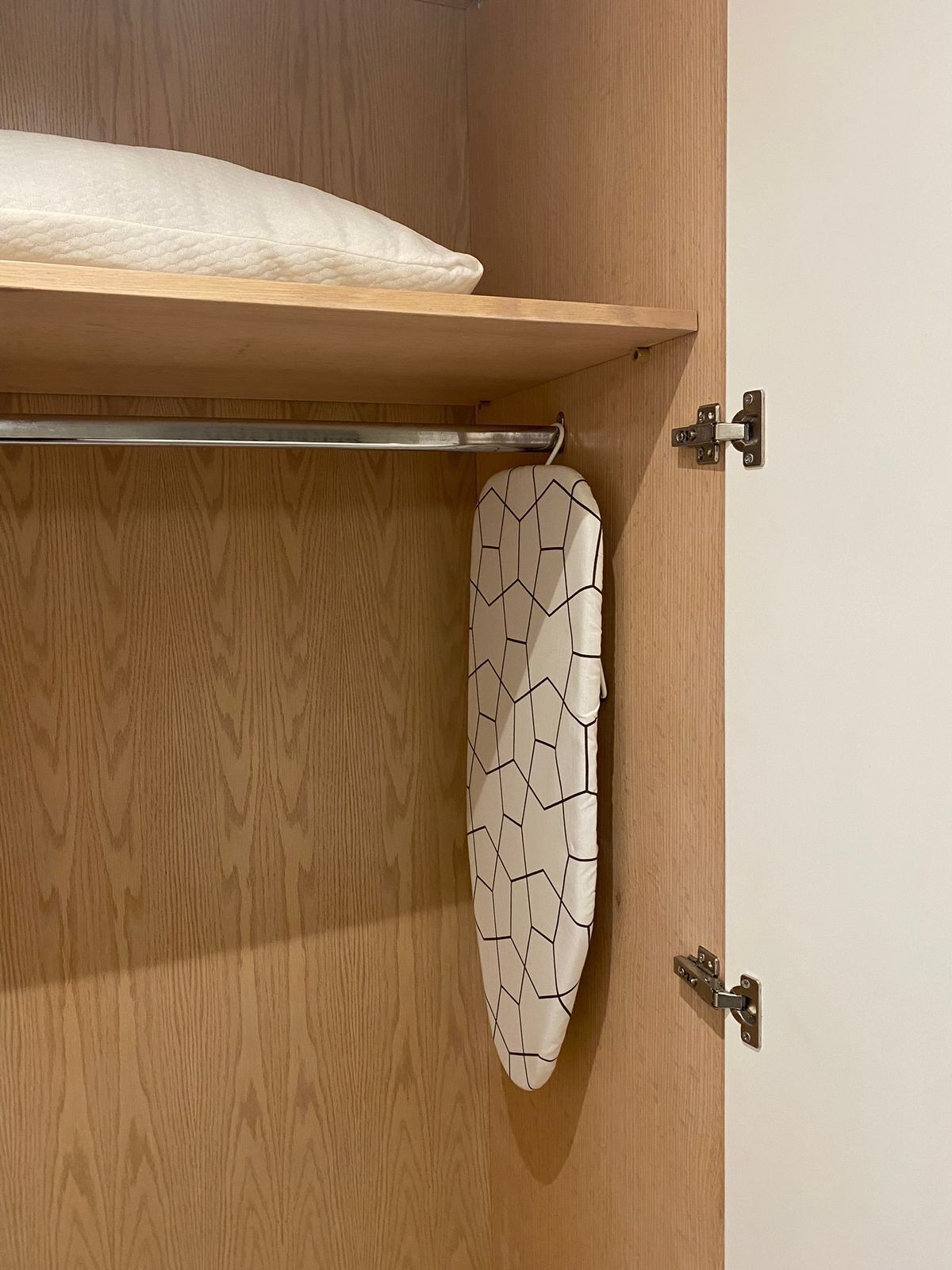 Un armario de madera con un estante y espacio para colgar ropa.