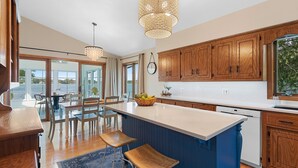 Una cocina moderna con armarios de madera, una isla grande y vistas al exterior.