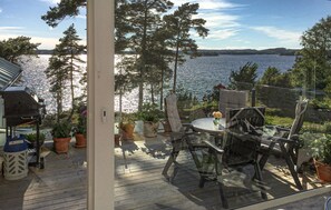 A deck with outdoor furniture, potted plants, and a view of a lake. - Pet friendly home in Alingsås with WiFi (Alingsås)