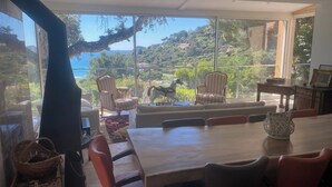 Un comedor amplio con una gran mesa y sillas, con vistas a una colina pintoresca.
