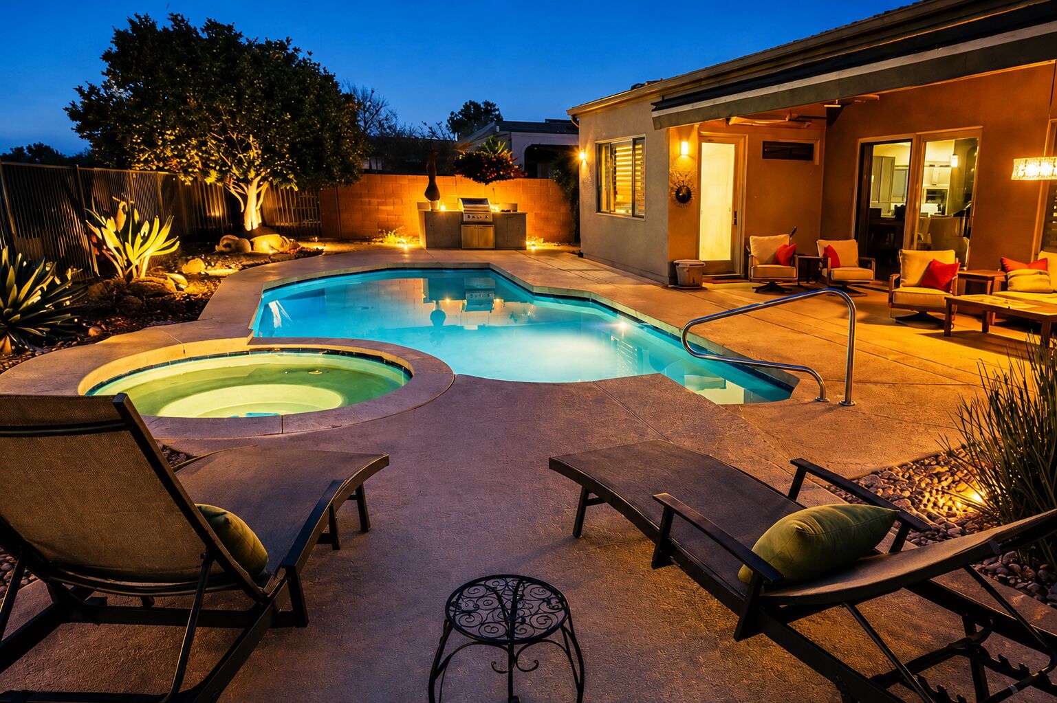 Una piscina con hidromasaje, mobiliario de exterior y zona de barbacoa.