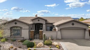 A single-story house with a garage, a front door, and a small garden with cacti and rocks. - 🌵 Anthem Country Club Retreat.  Heated Saltwater Pool, Spa, Casita & Office. (New River)
